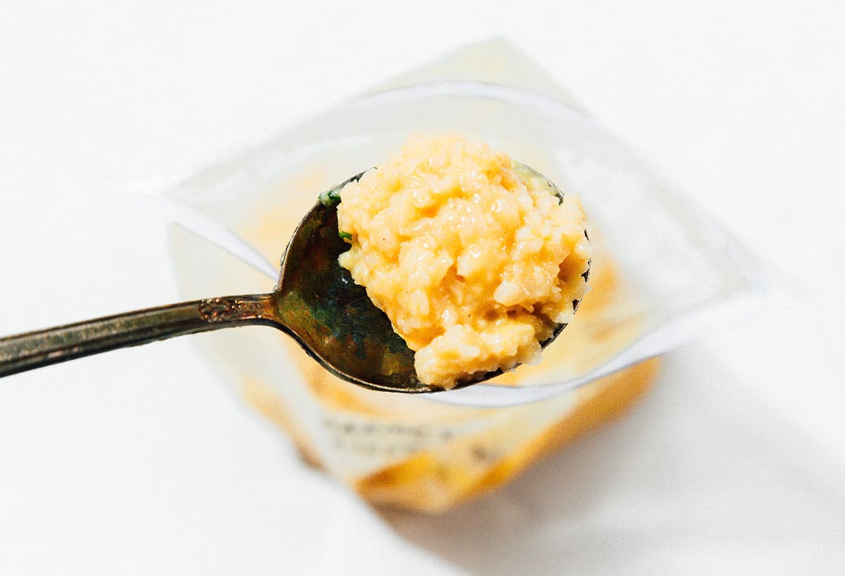 A spoon scooping out risotto from a bag.