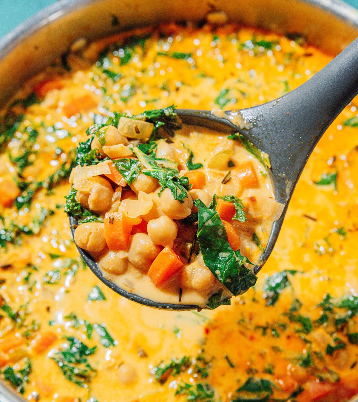 Chickpea soup in a pan with a ladle.