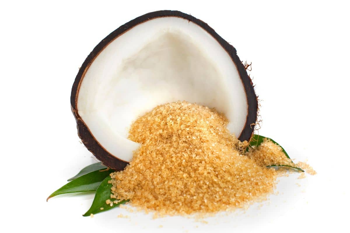 Coconut sugar in an open coconut on a white background.