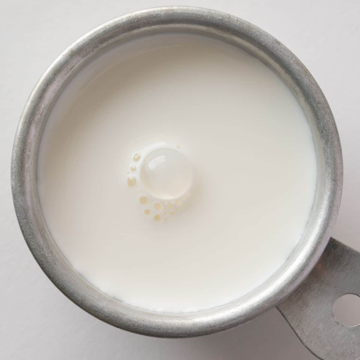 Heavy cream in a measuring cup.