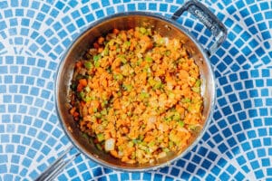 Onion, carrots, and celery in a saute pan.