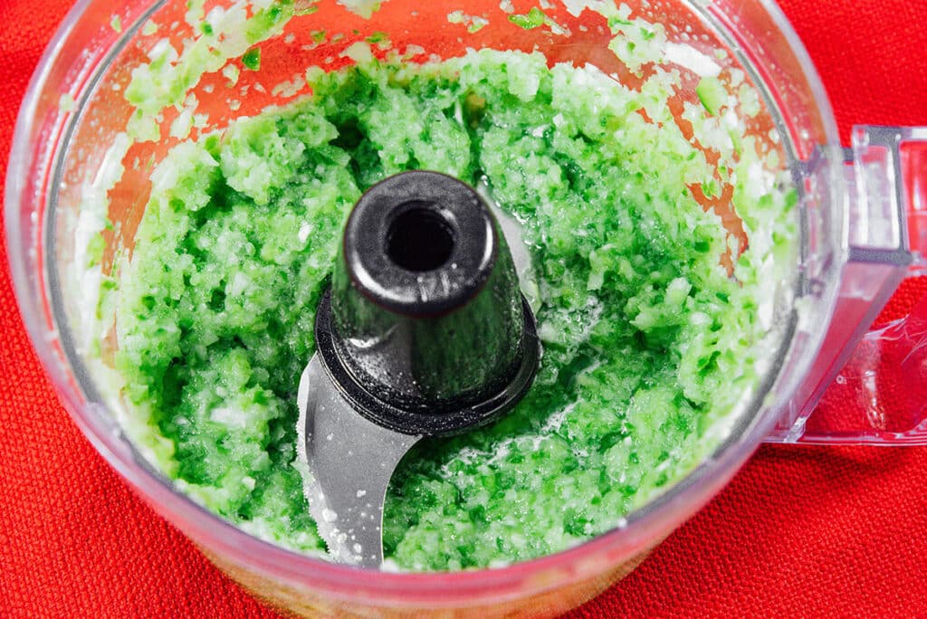 Pureed green pepper and onion in a food processor.