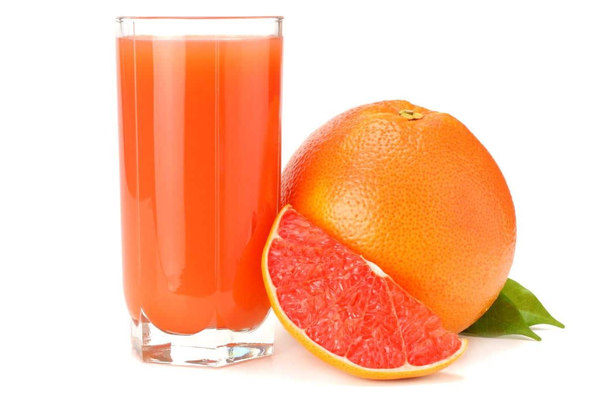 Grapefruit juice in a glass on a white background.