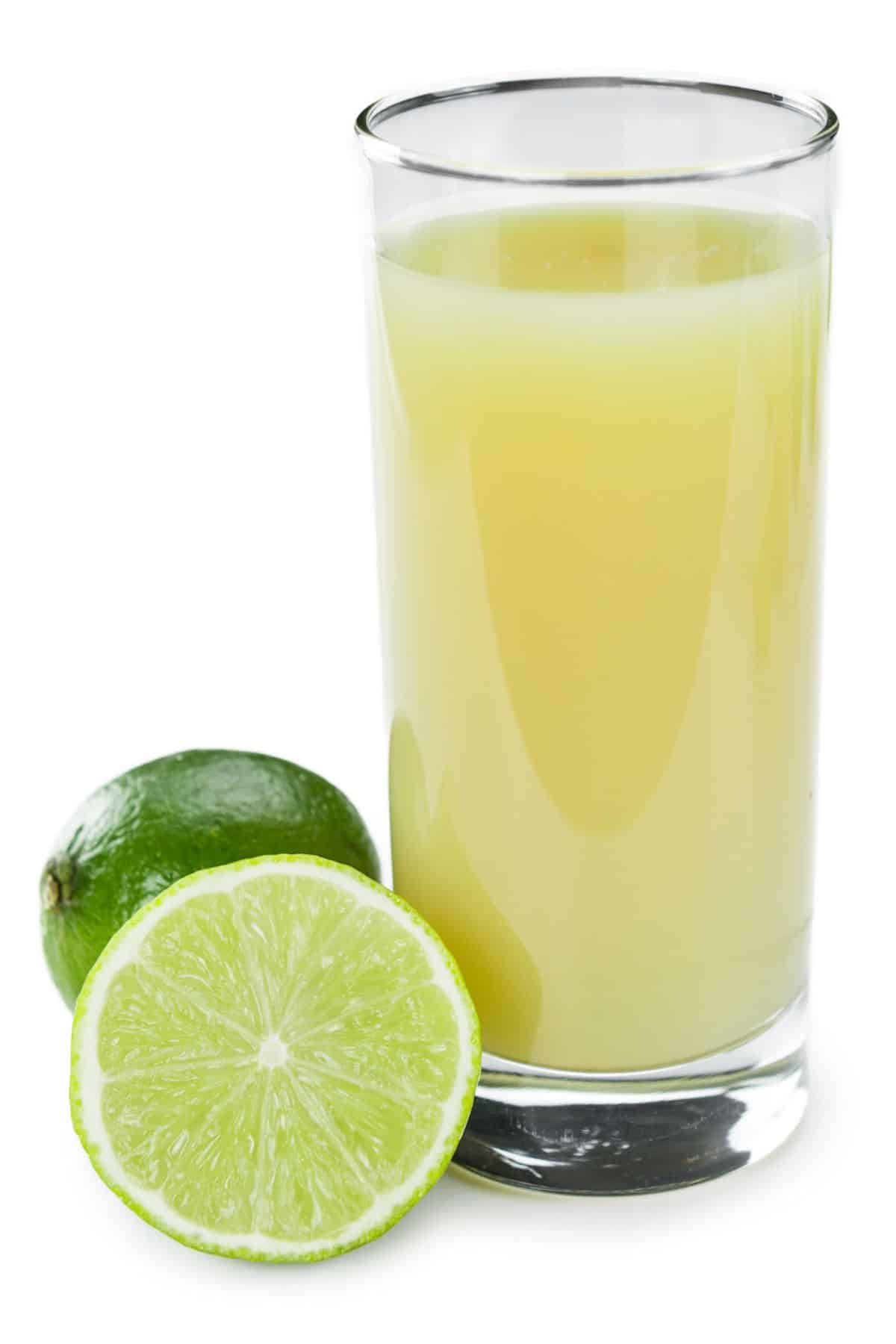 Lime juice in a glass on a white background.