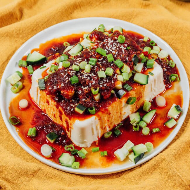 Silken tofu with spicy soy sauce and green onions on top.