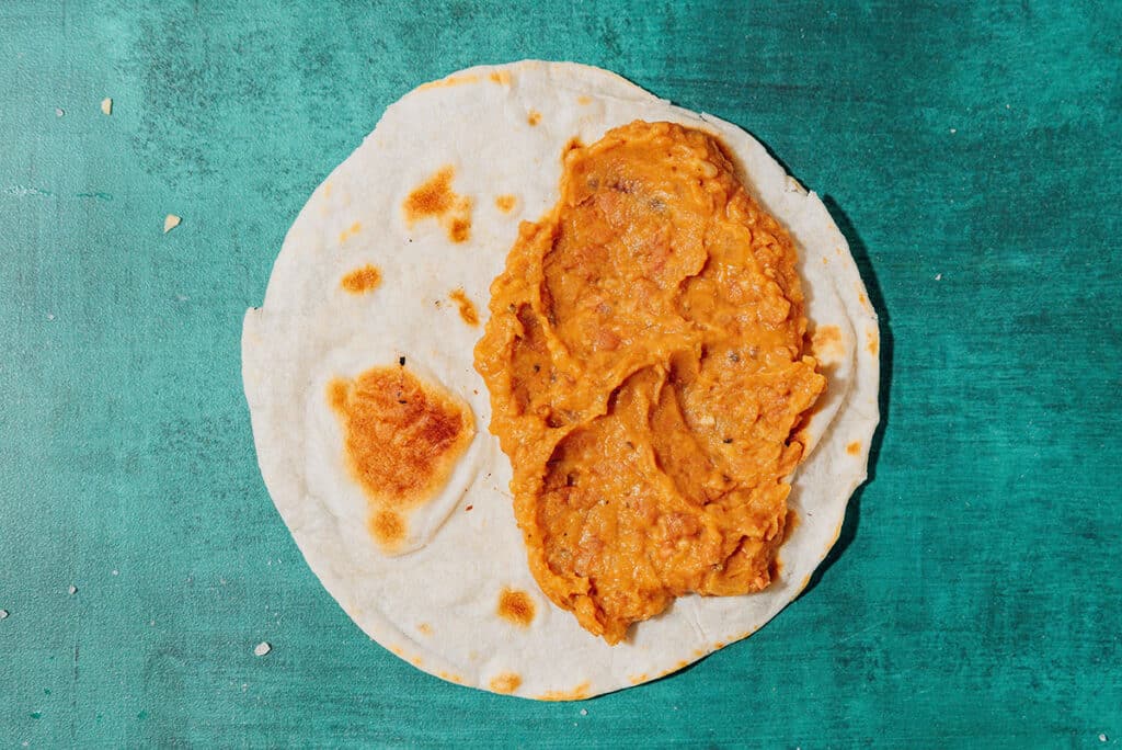 Tortilla with beans on a blue background.
