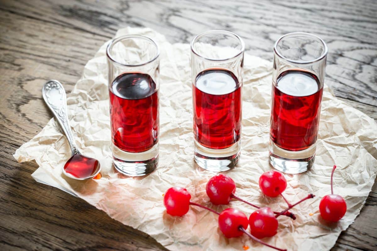 Three glasses of brandied cherries soaking.