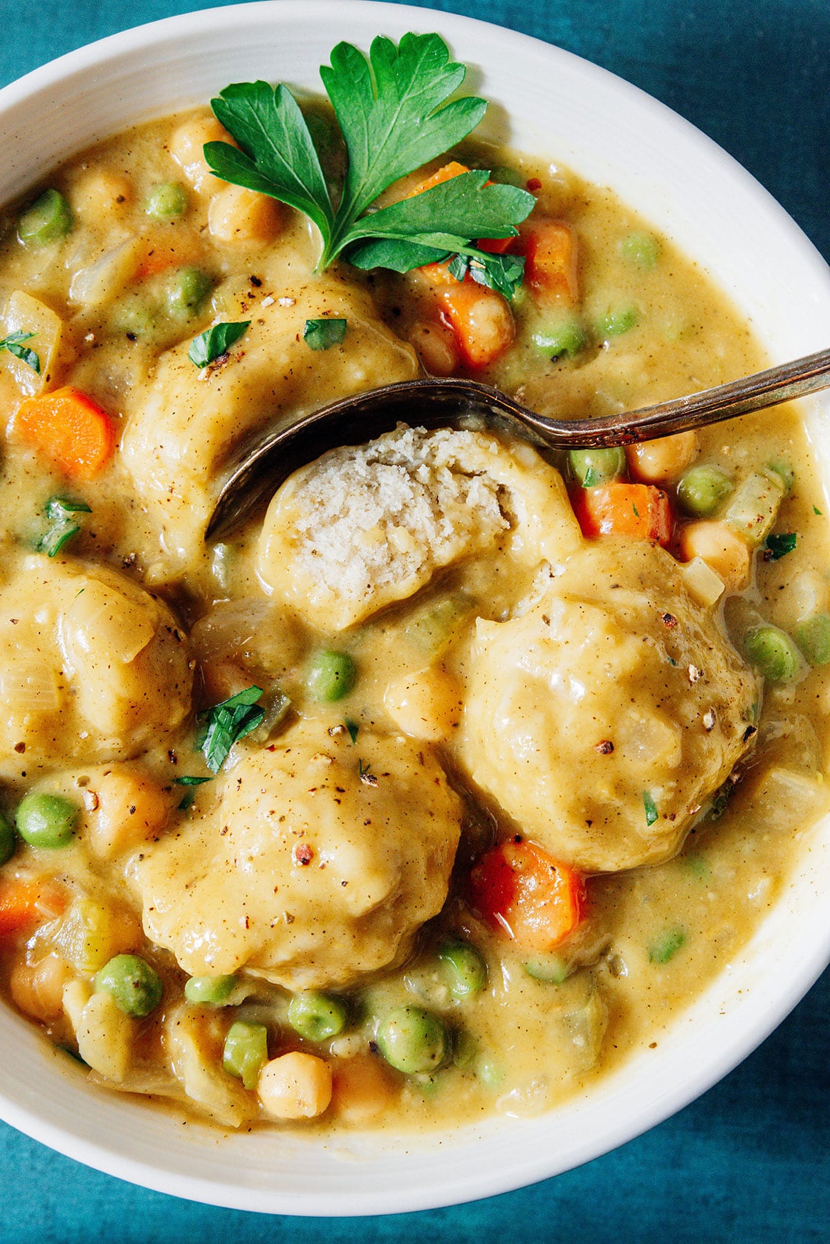 Vegan chicken and dumplings in a bowl, with a dumpling cut in half to show the inside.