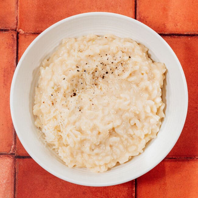 Risotto in a bowl on a tile background.