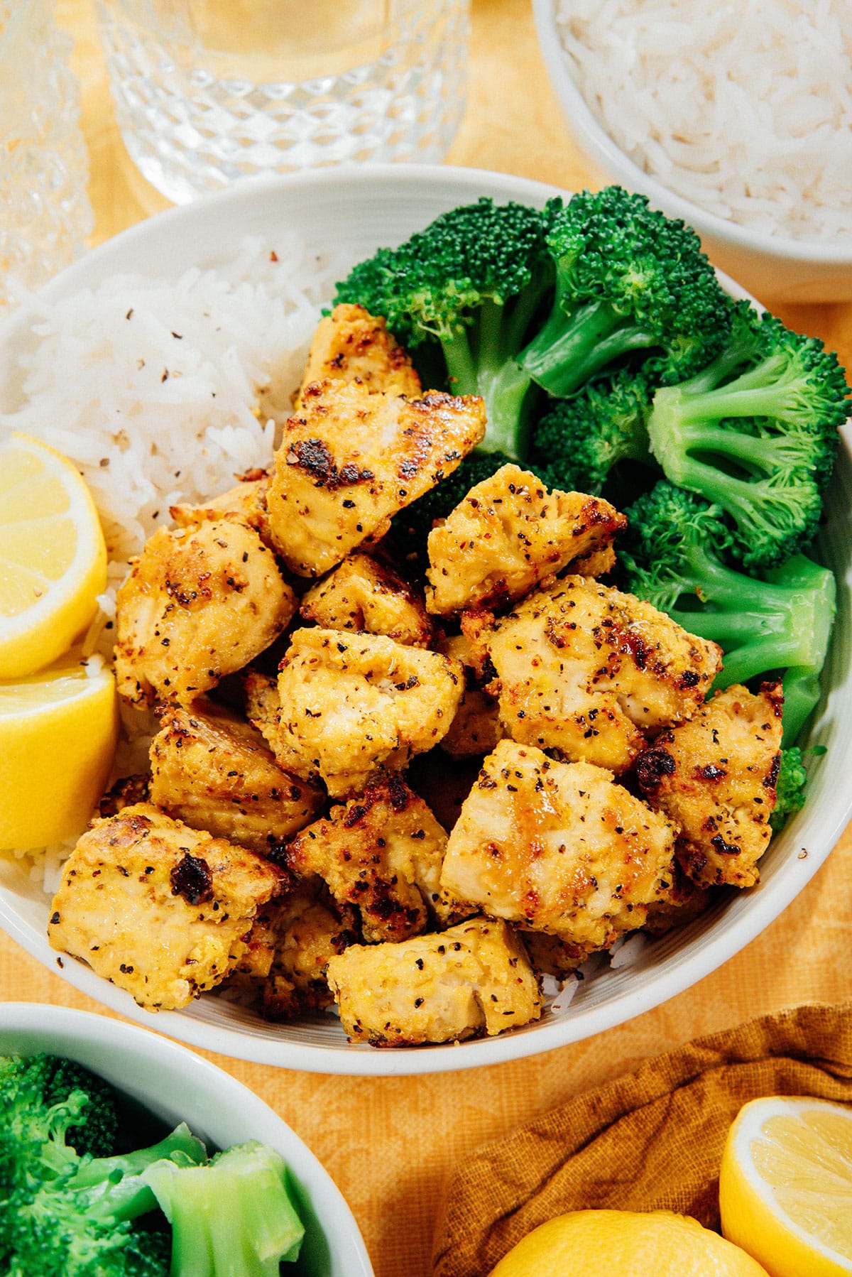 Lemon pepper tofu in a bowl with rice and broccoli.