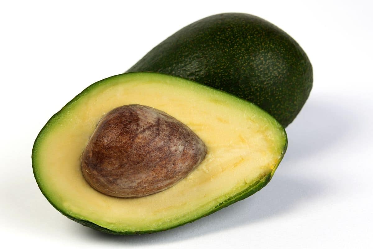 A cut open lulu avocado on a white background.