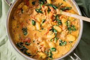 Gnocchi in a creamy Tuscan sauce and vegetarian sausage in a pan.