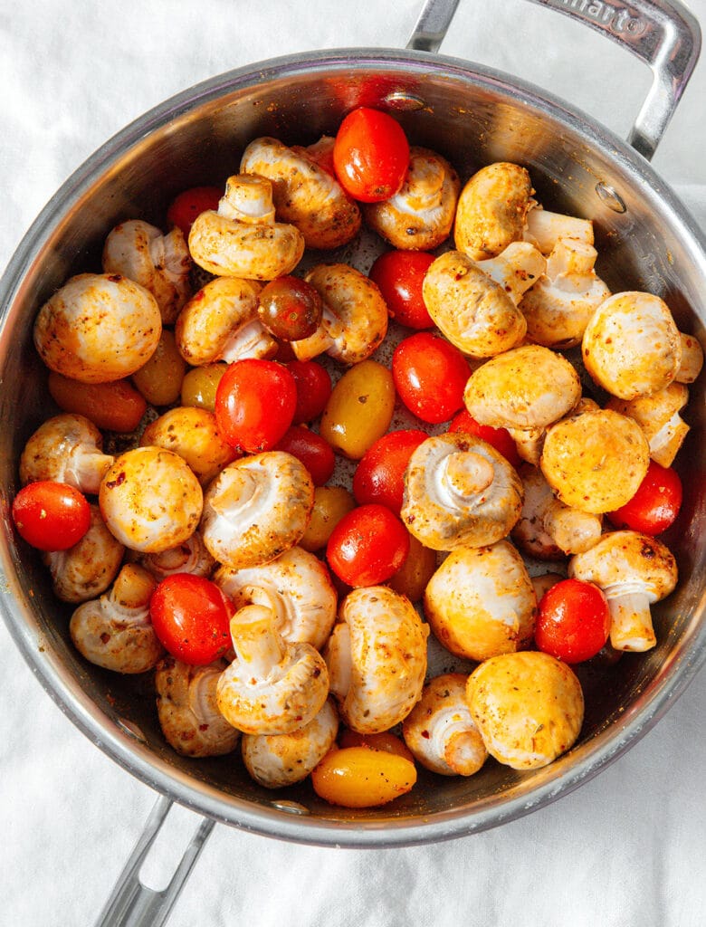 Tomatoes and mushrooms in a pan.
