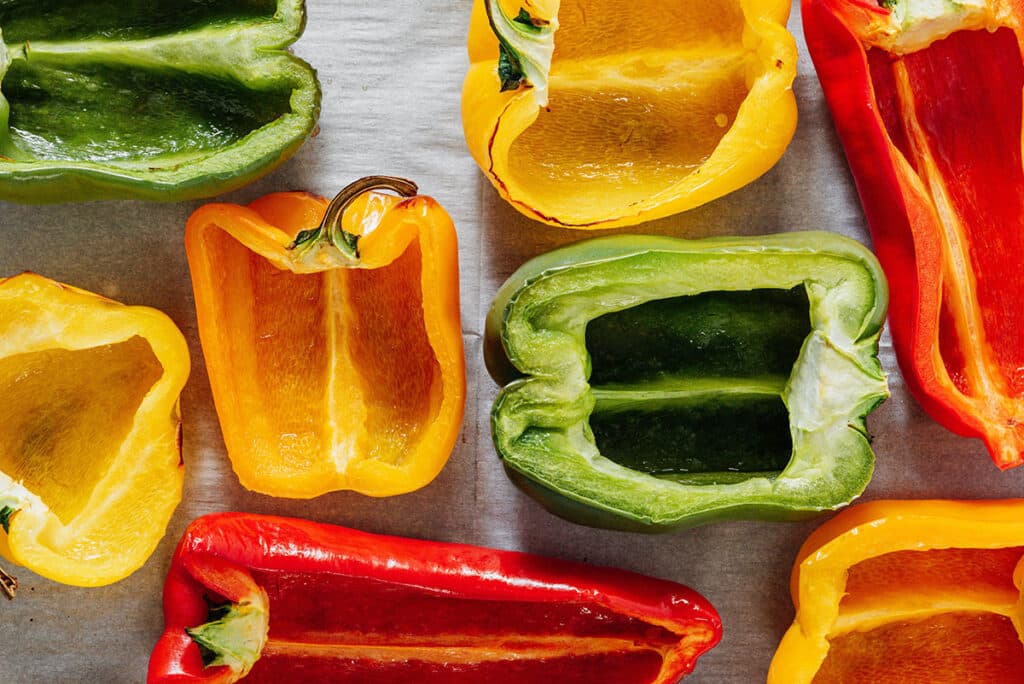 Halved bell peppers on a baking sheet.