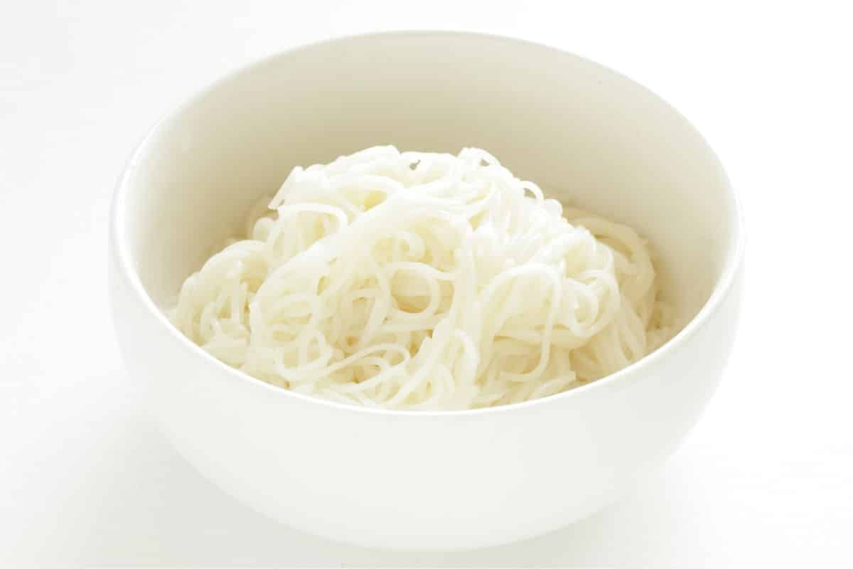 Somen noodles in a white bowl on a white background.
