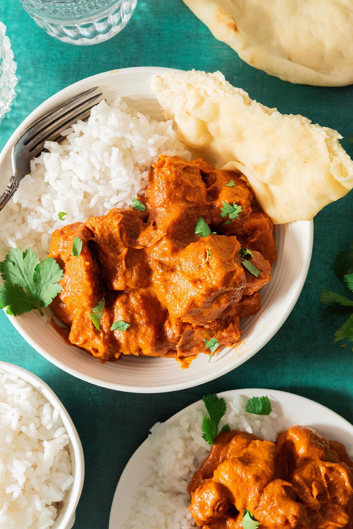 Vegan butter chicken on a plate with rice and naan.