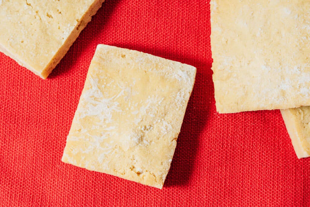Frozen tofu on a red backdrop.