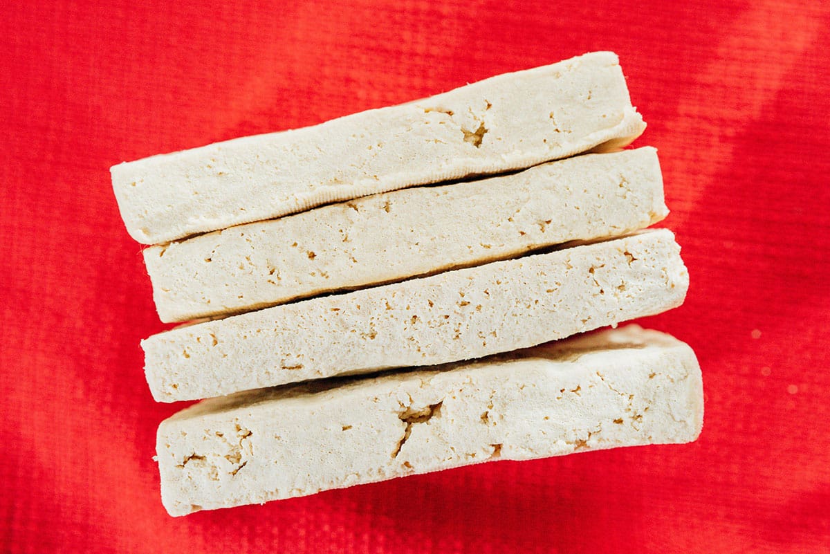 Tofu slabs on a red backdrop.