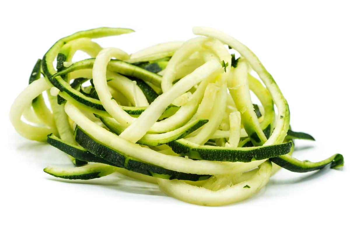 Zucchini noodles on a white background.