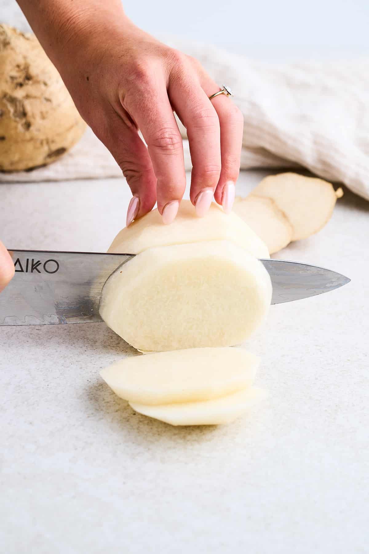 Cutting jicama into slabs.