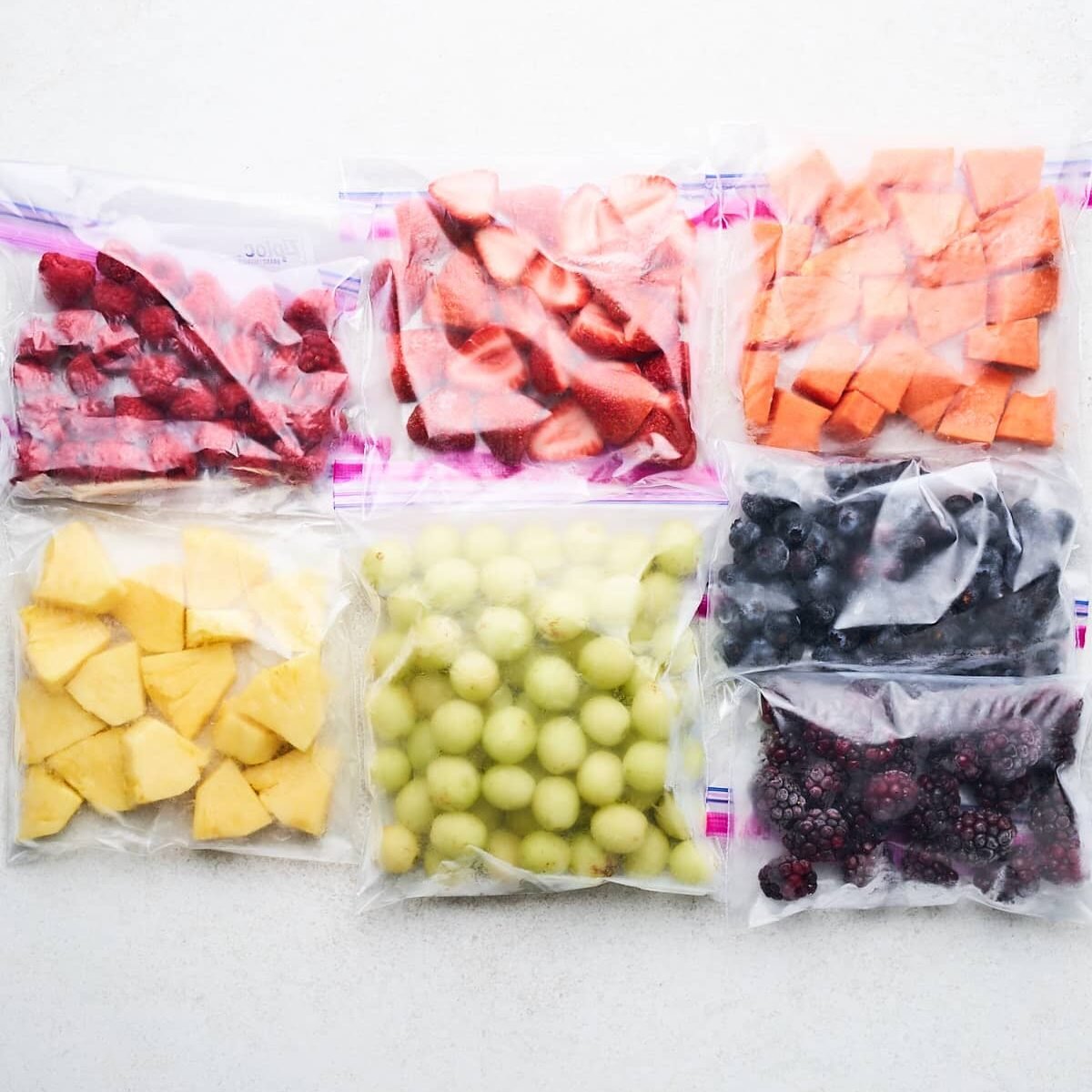 Frozen fruit chunks in bags.