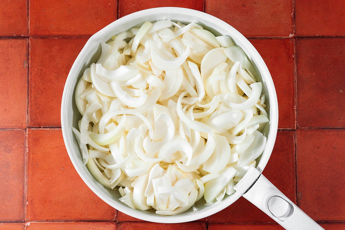 Sliced white onions in a pan.