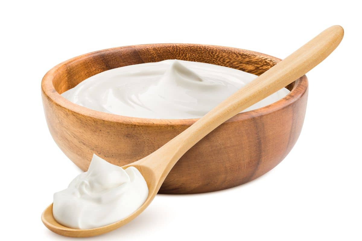 A bowl of lactose free yogurt on a white background.