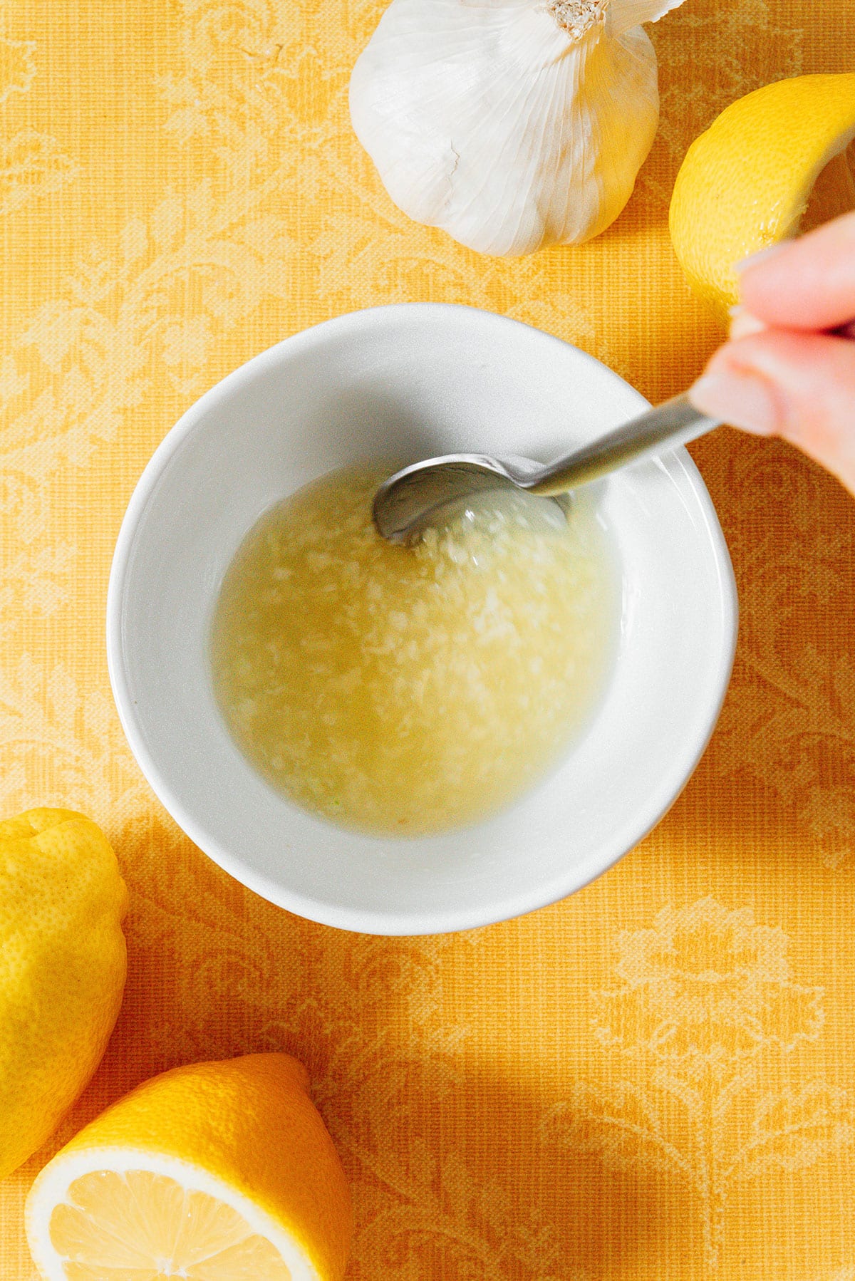 Stirring lemon and garlic in a bowl.