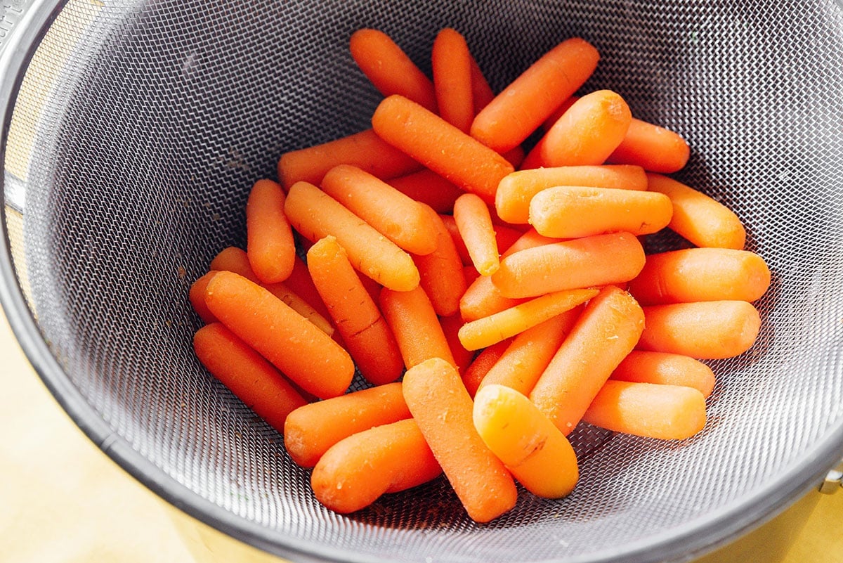 Draining carrots in a sieve.