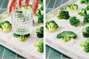 A hand uses a glass to press smashed broccoli florets onto shredded cheese on a parchment-lined baking sheet; photo shows before and after pressing.