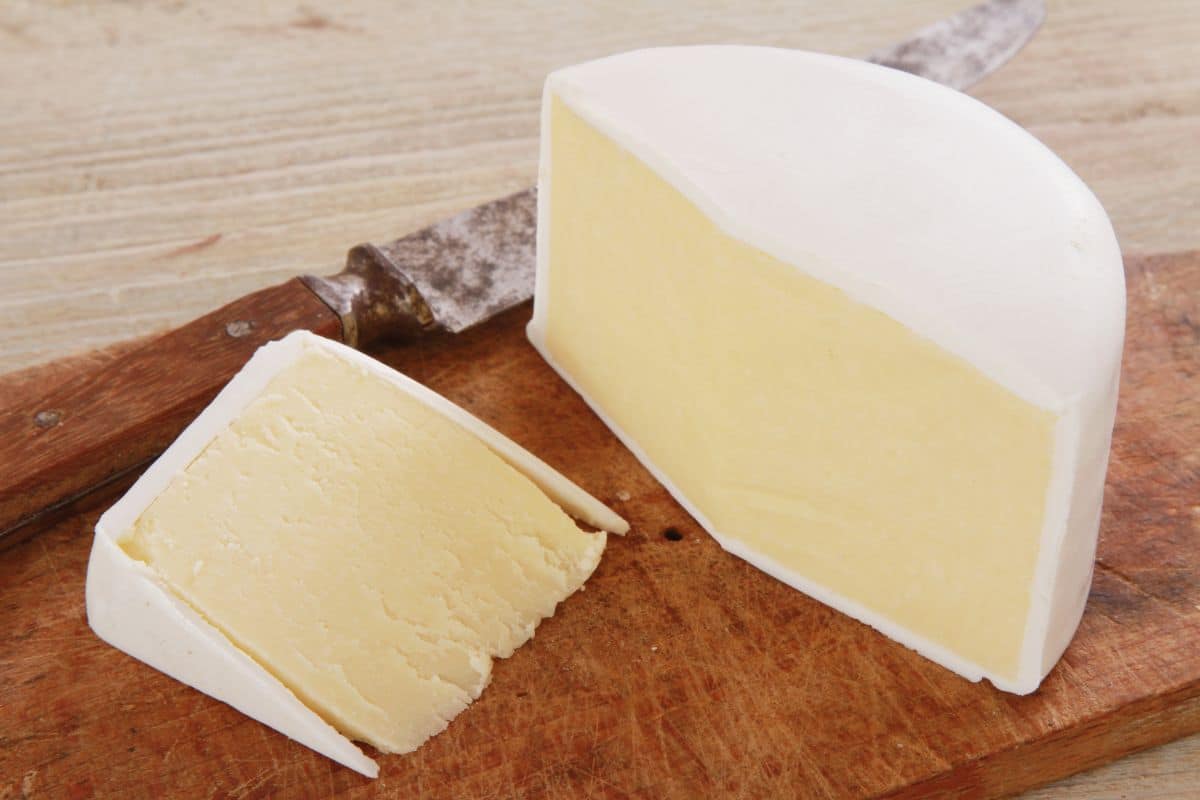 Wensleydale cheese on a wood cutting board.