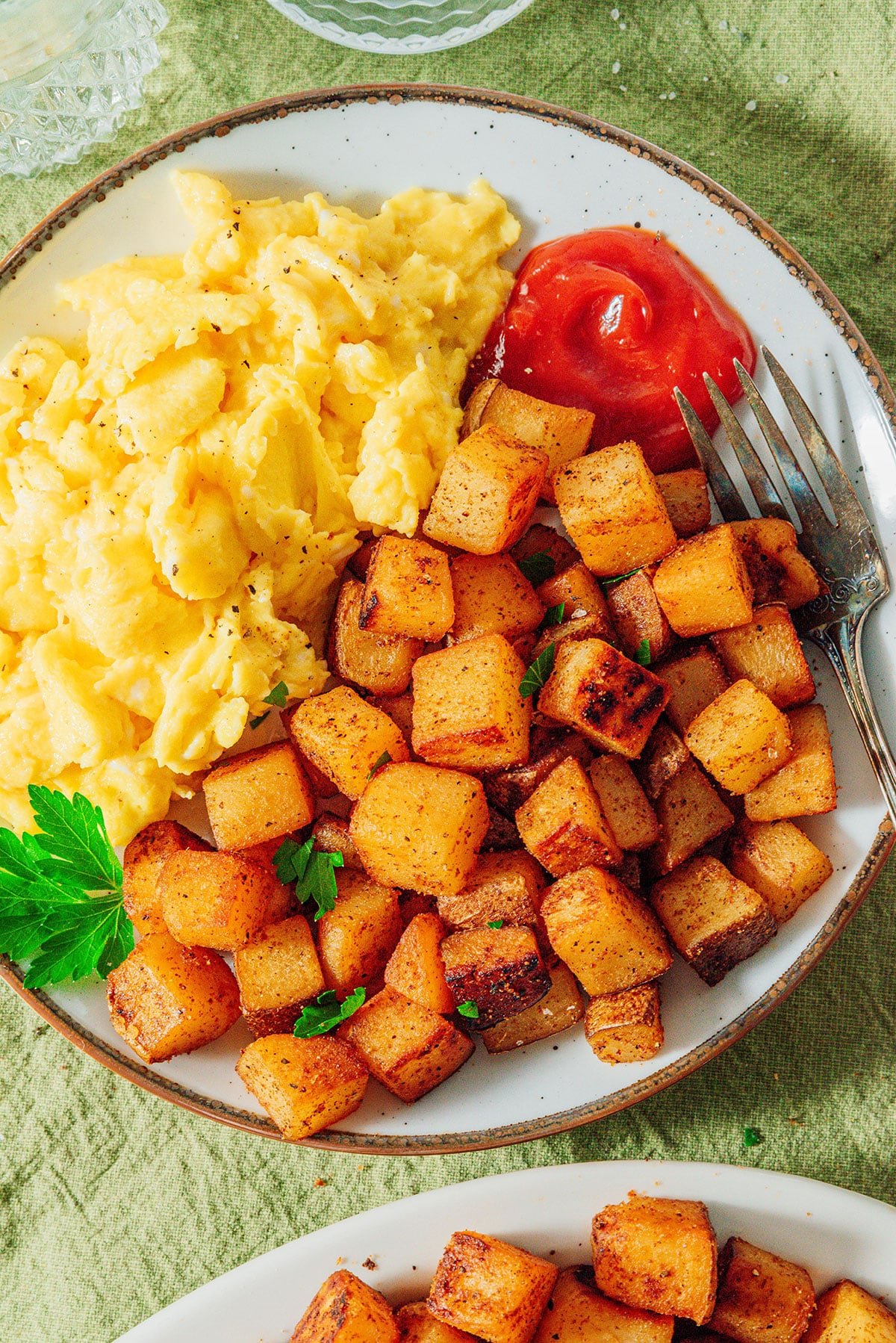 Breakfast potatoes with eggs and ketchup.