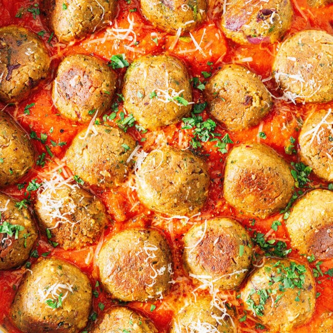 Chickpea meatballs in a pan with marinara sauce.