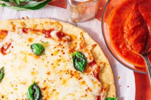 Chickpea pizza crust with cheese and basil.