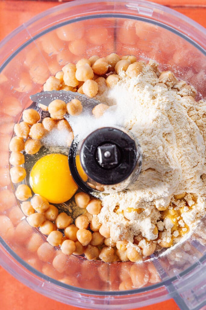 Ingredients for chickpea pizza crust in a food processor.