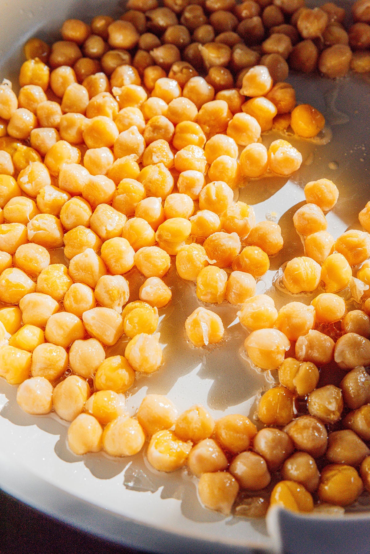 Frying chickpeas in a pan.