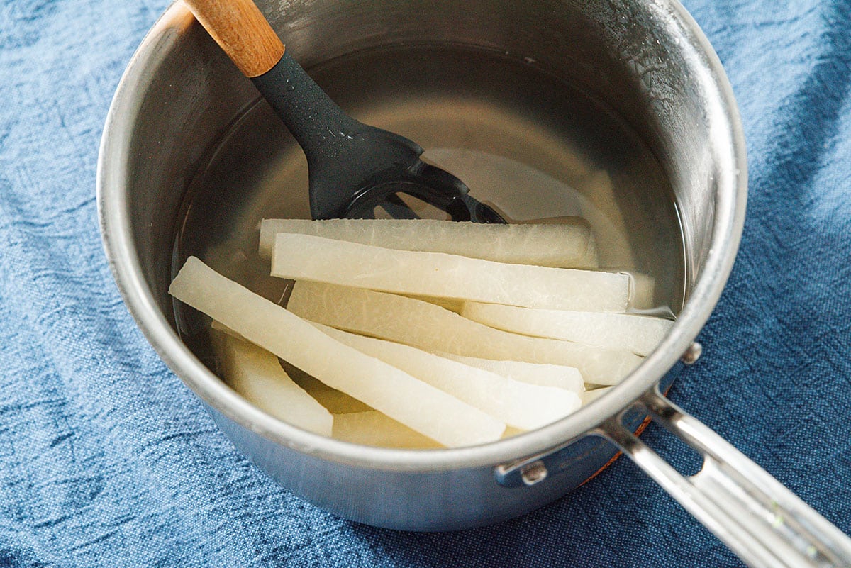 Boiling jicama sticks.