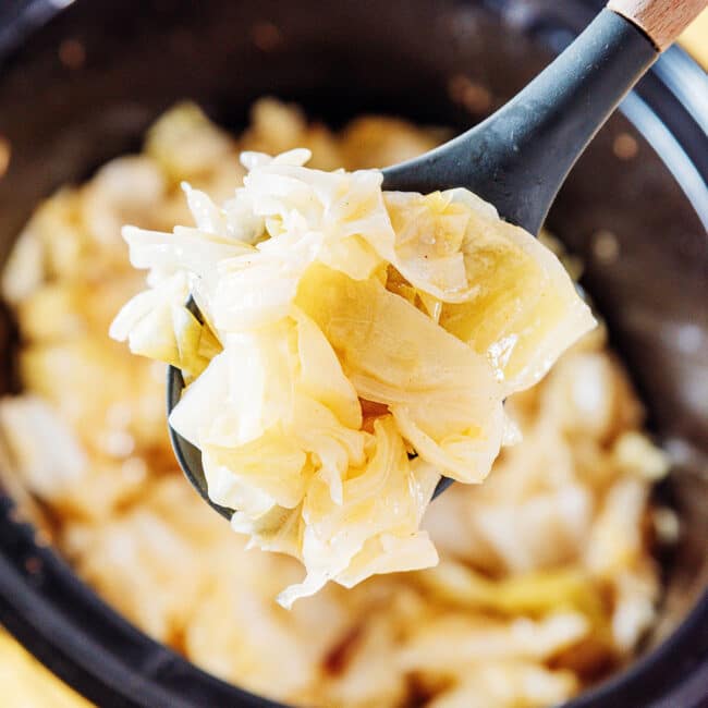 Slow cooker cabbage in a ladle.