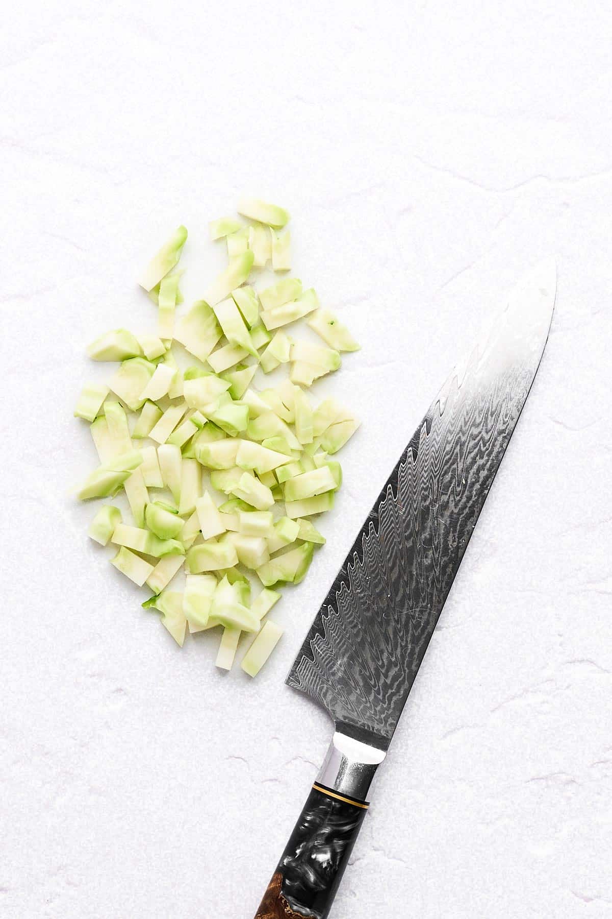 Diced broccoli stems and a chef's knife.