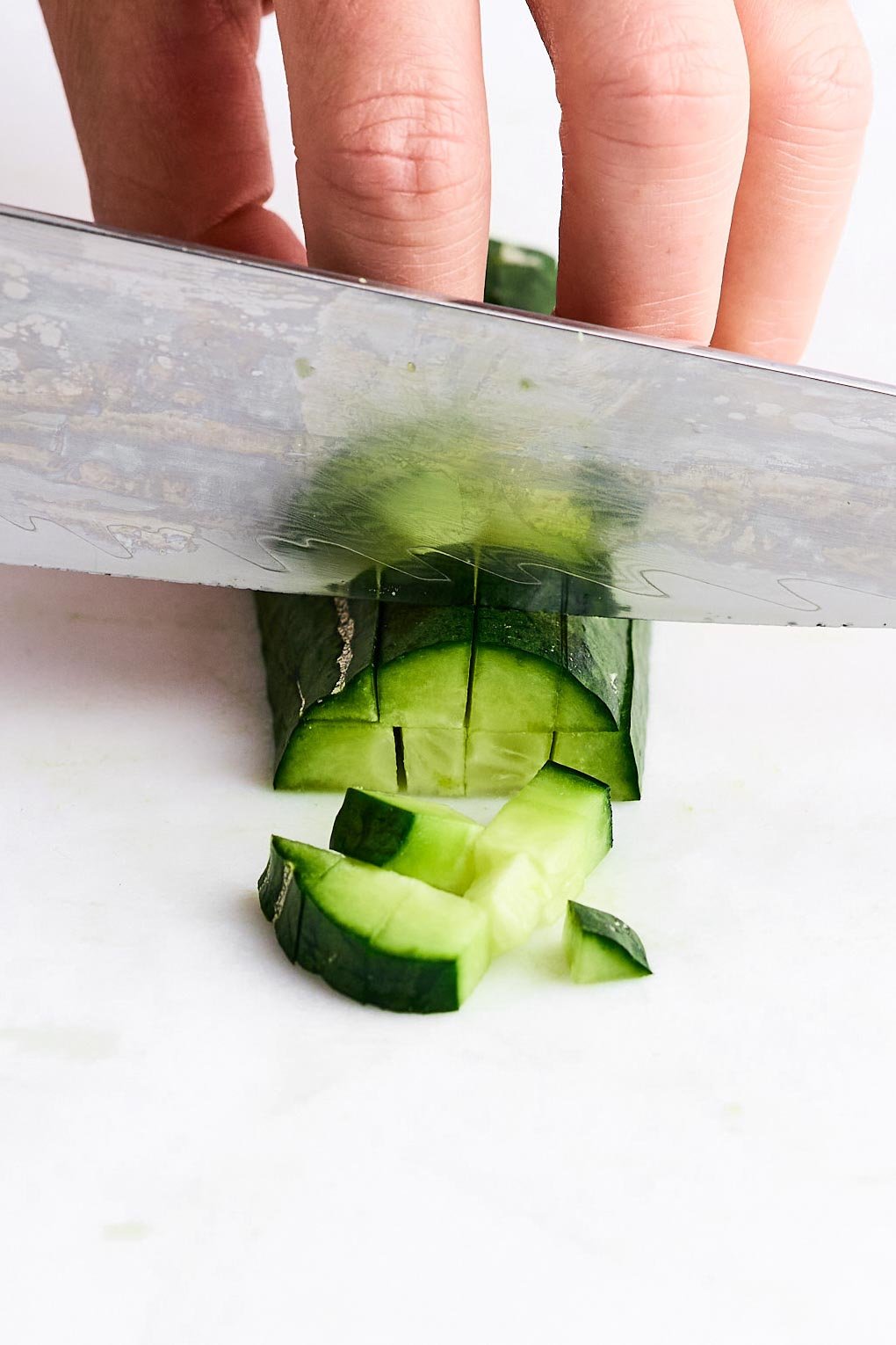 Cutting a cucumber into cubes.