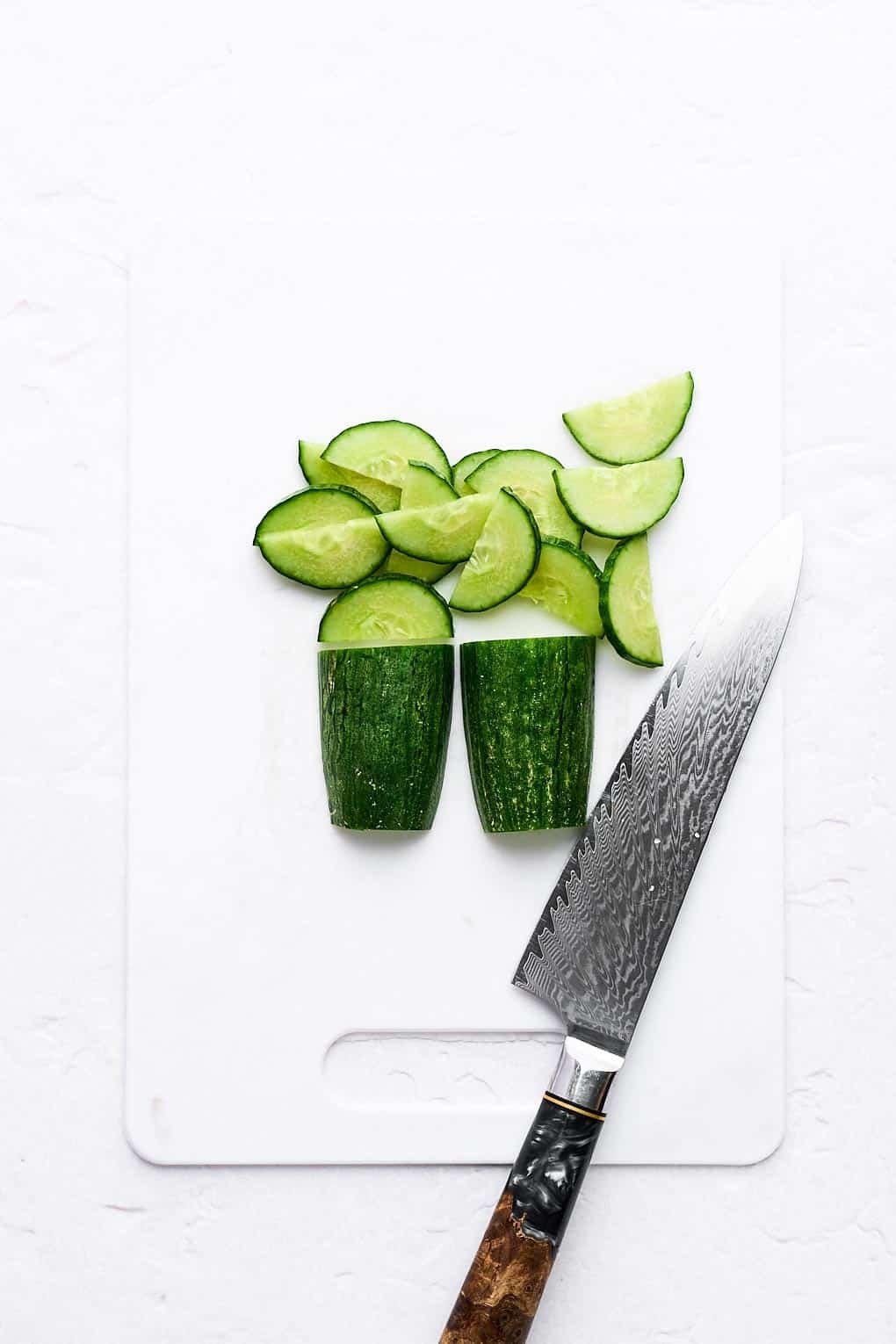 Cutting a cucumber into half moons.