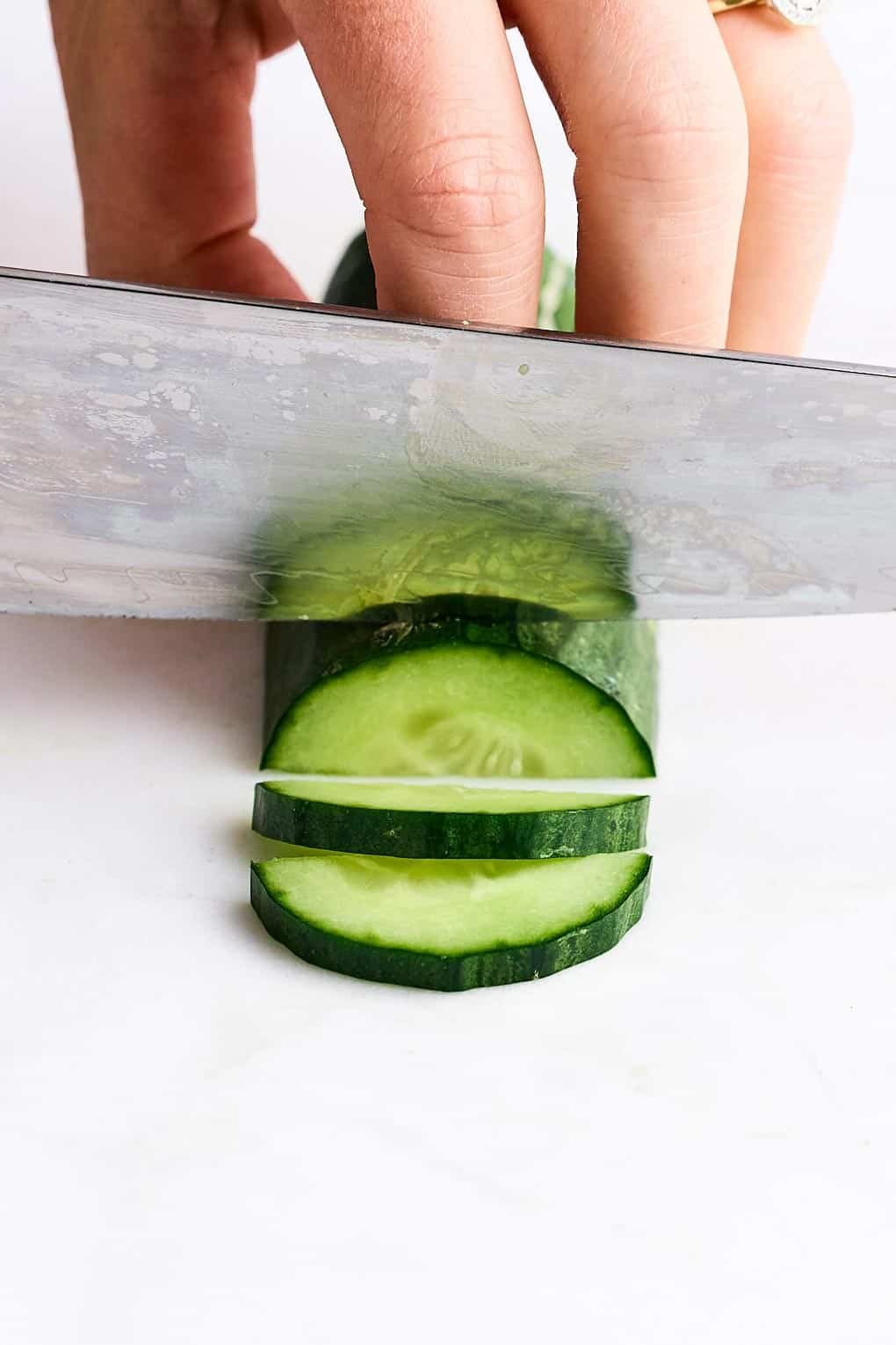 Cutting a cucumber into half moons.