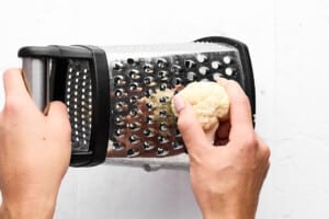 Grating cauliflower into rice.