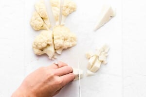 Cutting cauliflower cores into cubes.
