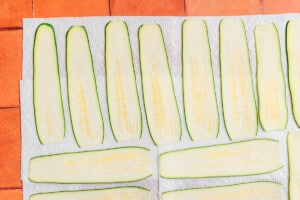 Zucchini cut thin on a tile.