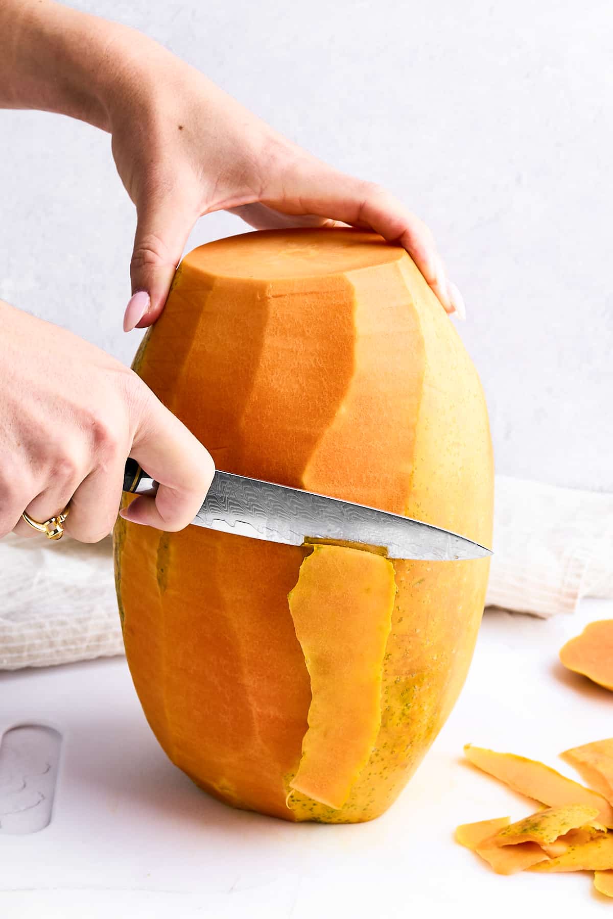 Peeling a papaya with a paring knife.