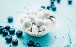 Frozen yogurt covered blueberries in a muffin cup.