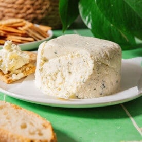 Homemade Boursin cheese on a green tile background.