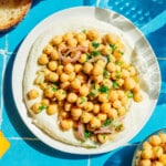 Marinated chickpeas with whipped feta on a blue tile table.
