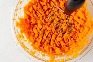 Mashing sweet potato.